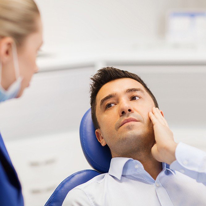 a dental patient holding cheek in pain
